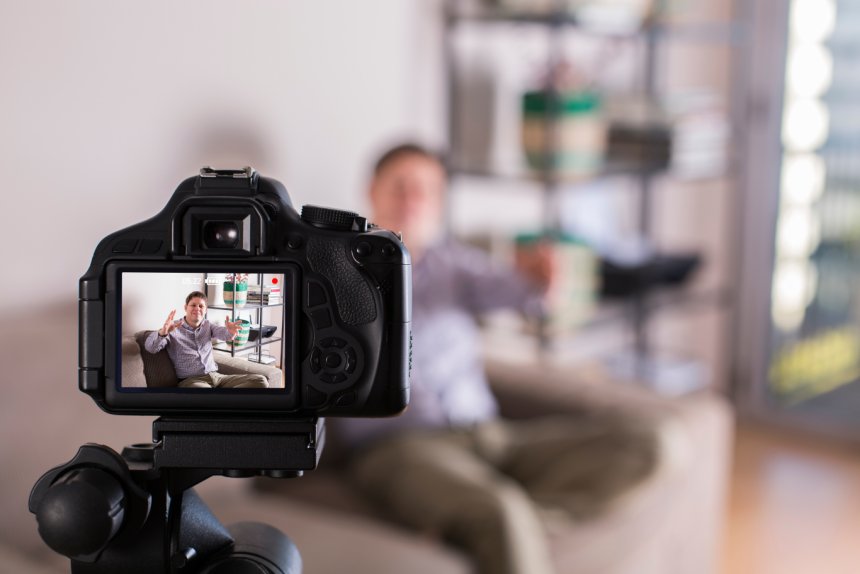 Guy recording himself with a camera for video marketing purposes.
