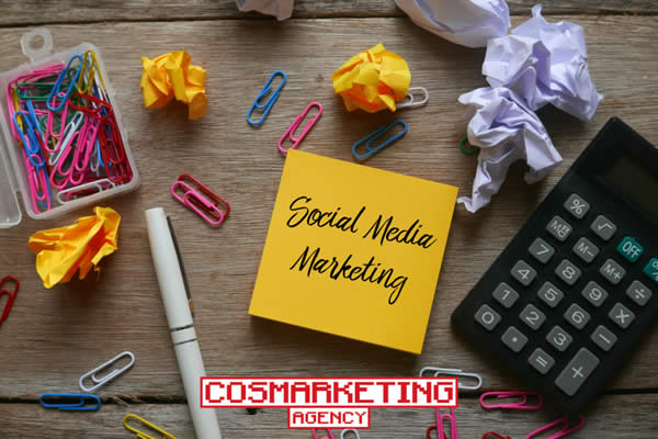 Paperclips, calculator, and a notepad with social media marketing written on it.
