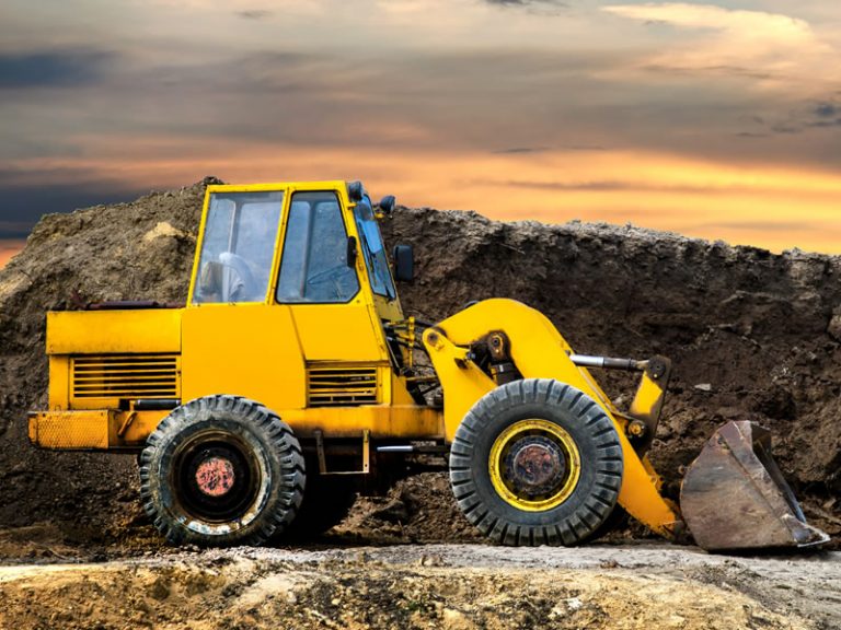 A front end loader construction vehicle on a construction site. Industries Marketing for construction companies
